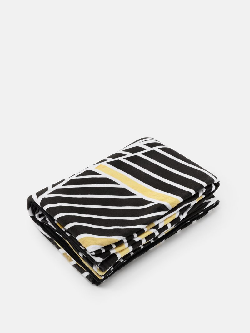 printed blankets folded on bed