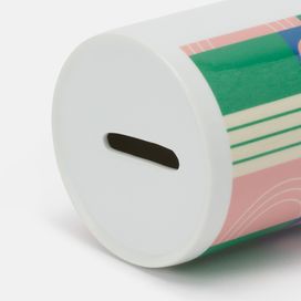 piggy bank printed with colourful artwork alongside table top accessories