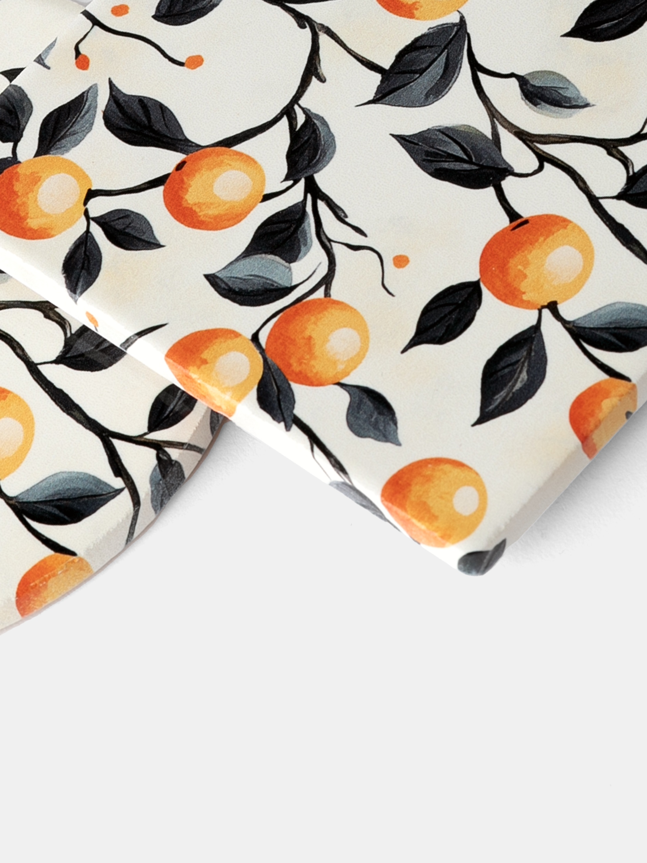 close-up of printed ceramic coaster with orange and leaf motif