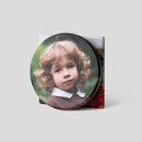 stacked photo coasters showing child portrait on ceramic surface